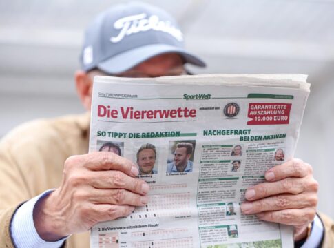 Rennbahnbesucher liest die Sportwelt mit der Viererwette